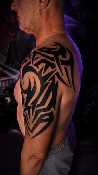 Tribal — Mocne wypełnienie na męskim ramieniu